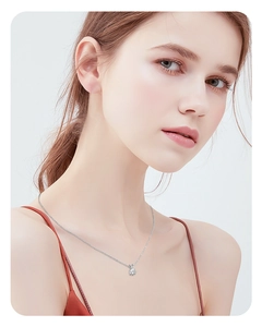 Close-up of a 1 carat round brilliant moissanite pendant on a silver necklace worn by a model