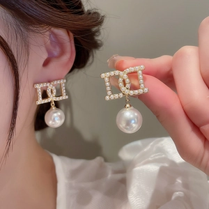 Elegant gold drop earrings with D-letter pearl design and large white round pearls