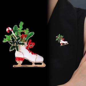 Christmas ice skate brooch with holly and candy cane details on dark clothing
