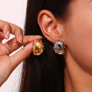 Detailed view of irregular 18K gold earrings with multi-colored micro-paved zircons