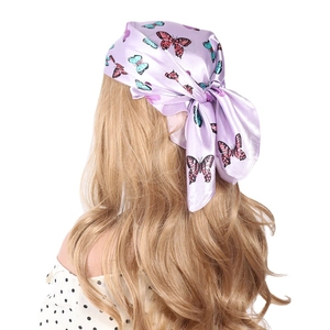 Elegant 60cm square silk scarf with butterfly print tied on blonde hair in a ponytail