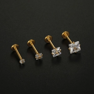 Detailed close-up of four gold labret studs with square zircons in varying sizes