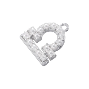 Macro shot of silver letter B charm inlaid with pearls for DIY jewelry making