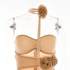 Détail du tissu en maille abricot avec décorations de roses 3D et texture plissée