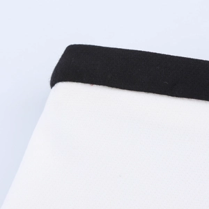 Detailed close-up showing the high-quality white cotton fabric texture and black edge piping