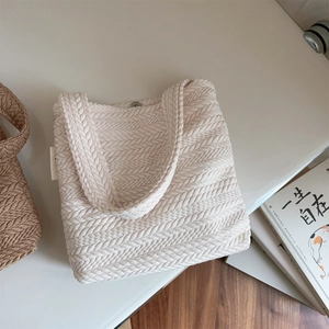 Detailed macro view of the textured rice-spike knit pattern on a beige canvas tote bag