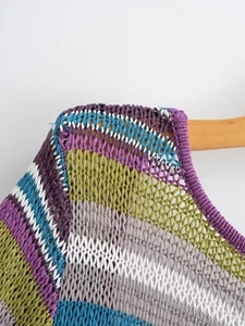 Detail der bunt gestreiften, durchbrochenen Strickkleid-Schulterpartie mit Stoffstruktur