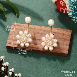 Detailed view of pearl flower earrings with dimensions 2.9cm by 1.64cm on wood stand
