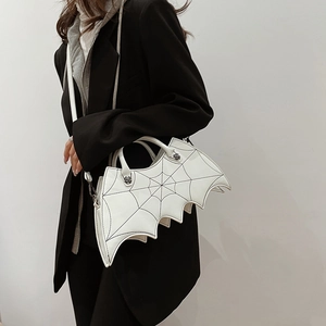 Gothic white bat wing bag with spider web stitching and skull hardware worn by a model
