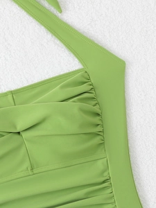 Detail of lime green ruched swimsuit showing smooth nylon texture and precise stitching