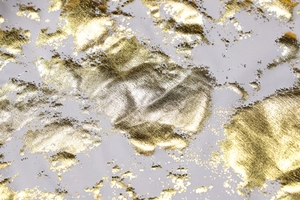 Macro view of white dress fabric with textured gold foil abstract patterns and metallic finish