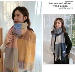 Detail of soft thick cashmere-like scarf with color block plaid patterns and long tassels