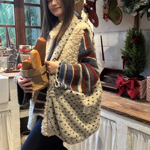 Detail of plush beige teddy tote bag with blue stars in a cozy winter setting