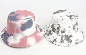 Detail of tie-dye bucket hats in warm red-blue and cool black-white cotton fabric