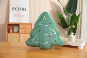 Detailed close-up of green plush Christmas tree pillow with colorful polka dot embroidery