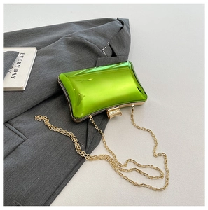 Detail einer glänzenden lindgrünen Hartschalen-Clutch mit Goldkette und Metallverschluss