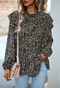 Dettaglio della camicetta in chiffon floreale con colletto a balze e spalline ruffles