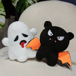 Plush Halloween ghost and black devil doll with orange wings on a cozy white sofa