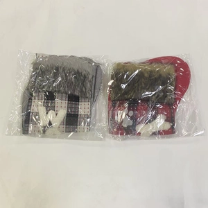 Detail of plaid Christmas stockings with plush fur collars in clear plastic packaging