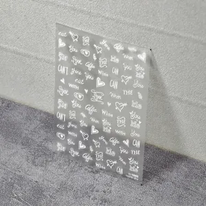 Minimalistische weiße Nagelsticker mit Buchstaben und Herzen auf transparenter Folie