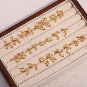 Detailed view of 12 pairs of 18K gold-plated zodiac stud earrings with sparkling crystals