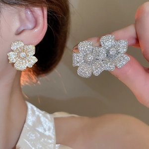 Macro shot of silver floral earrings and ring set with sparkling pave-set cubic zirconia