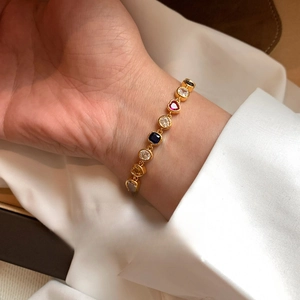 Bracelet plaqué or 18 carats avec zircons cœur et carrés sur le poignet d'une femme