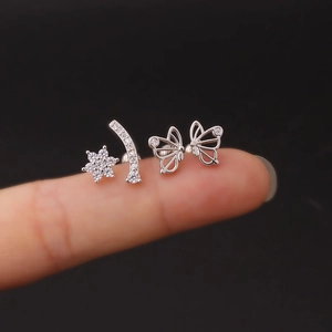 Silver stainless steel butterfly and zircon star stud earrings shown on finger