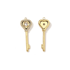 Detailed view of gold heart key pendants showing front crystal and back finish