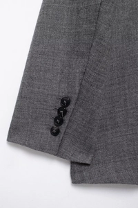 Detailed macro view of grey wool-blend blazer cuff with four black buttons and fabric texture