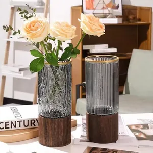 Modern grey glass vase with wooden base and gold rim for stylish home decor display