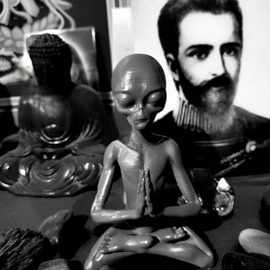 Detailed view of meditating resin alien figurine with intricate textured gray finish