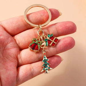 Detailed view of Christmas keychain with gold bell, gift box and tree charms