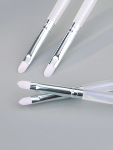 Detail of four colorful makeup brushes with soft white bristles and pearly handles