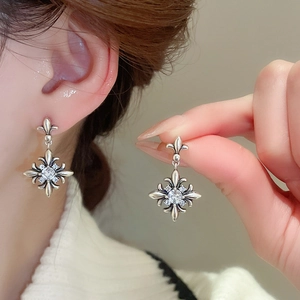 Detailed view of vintage silver iris flower earrings with sparkling zircon stones