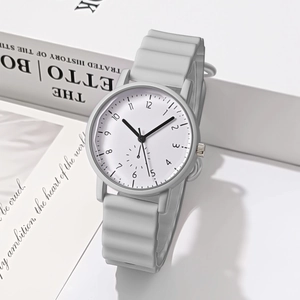 Minimalist light grey quartz watch with wavy silicone strap on artistic book background