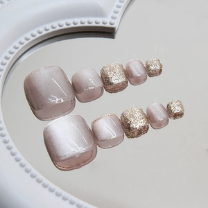Cat eye and glitter press-on toe nails in nude pink finish on a mirror tray