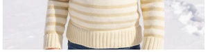 Detailed close-up of winter striped knit sweater with thick ribbed cuffs on snowy background