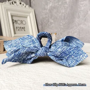 Detail of 11cm blue denim bow claw clip with delicate white bead embellishments