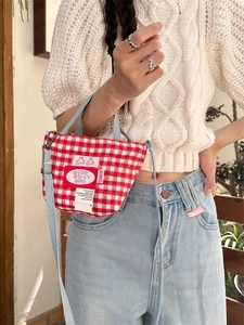 Red and white checkered wool tote bag with light blue denim strap worn by a model