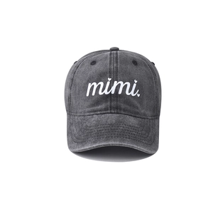 Close-up of washed black baseball cap featuring white mimi embroidery and heart detail