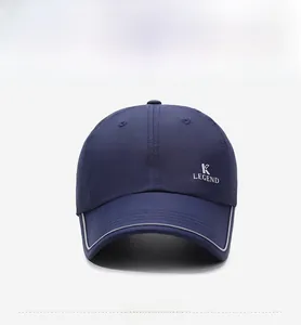 Detail view of navy blue baseball cap featuring silver K LEGEND logo and reflective trim