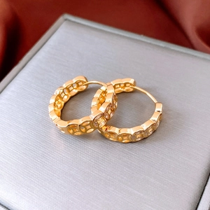 Detail of 18K gold plated coin earrings with crystals on a luxury display box