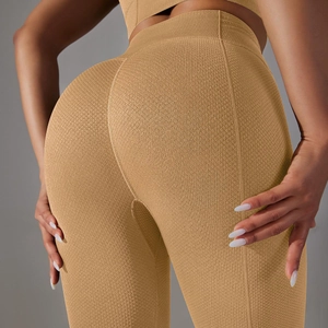 Close-up of mustard yellow high-waisted seamless yoga pants with honeycomb texture