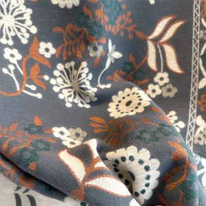 Close-up of floral cashmere feel scarf fabric in dark grey with soft white and brown patterns