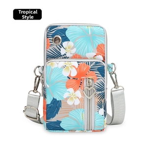 Detail of tropical print oxford fabric phone bag with dual zippers and heart charms
