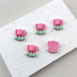 Detailed macro view of 5 pink resin tulip charms for DIY jewelry and hair accessories