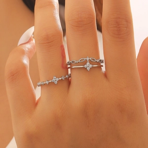 Close-up of silver-tone layered rings with zircon clover design on model's hand