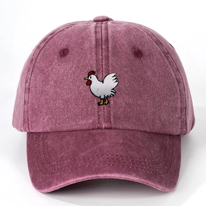 Close-up of white rooster embroidery on washed burgundy cotton twill baseball cap