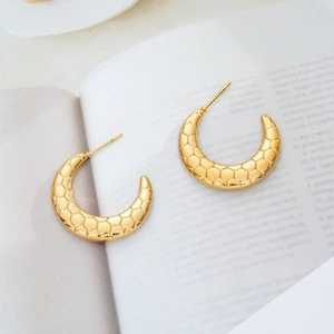 Macro shot of 18K gold-plated titanium steel earrings with honeycomb embossed pattern